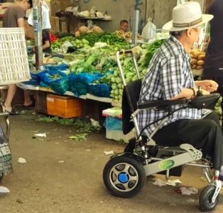 ​69岁洪金宝坐轮椅进菜市场被人偷拍，保姆现身保护，未见妻子身影